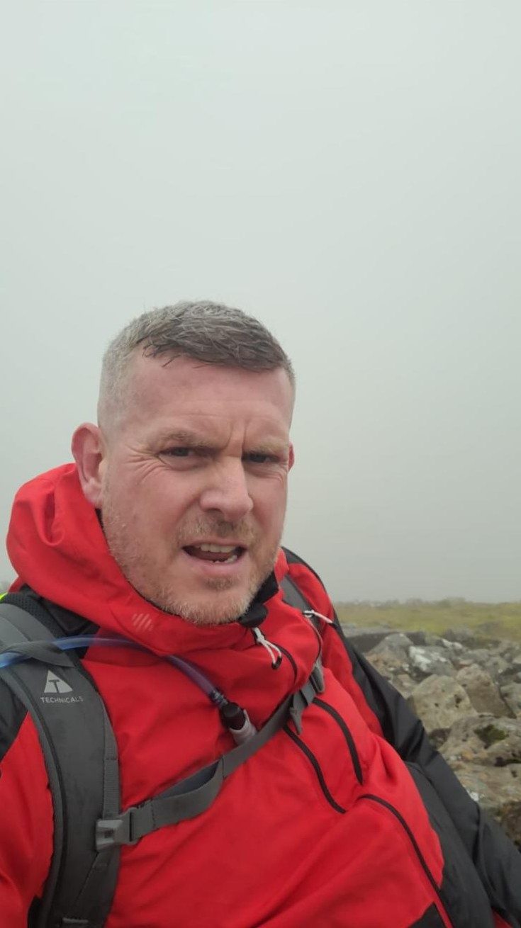 Scott Glover in a red rucksack on a hill walk