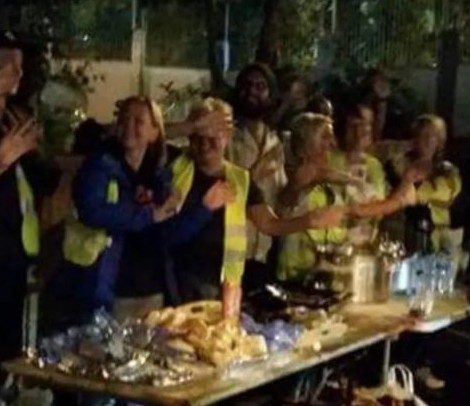 Volunteers in hi-vis serving a community soup kitchen